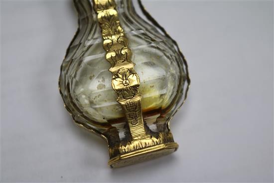 A late 18th century French yellow metal mounted glass scent bottle, with pierced removable finial.